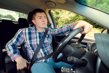 Ciddi yakışıklı genç arabasını ekose gömlekli. Direksiyonun arkasında iş adamı. Arabada oturan ve direksiyon tutan adam