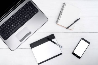 Üstten görünüm açık dizüstü bilgisayar, boş, boş günlüğü ve grafik tablet, boş alan beyaz tahta masada. Cep telefonu ile beyaz perde, kopya alanı 
