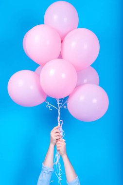 Uçan balon adam elinde beyaz arka plan üzerinde izole mavi hava. Tutan pek çok pembe hava balonları, boş alan mavi tişörtlü adam. Yaz, tatil, kutlama, Doğum günün kutlu ve yaşam tarzı kavramı