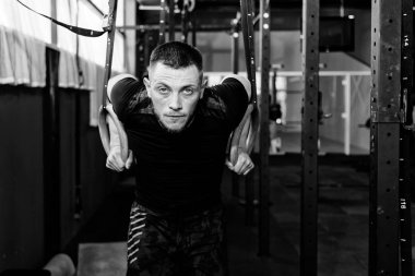 Atlet kasları halkalar üzerinde çalışıyor. Spor salonu pull UPS Jimnastik halkalar ile çalışma dışarı adam