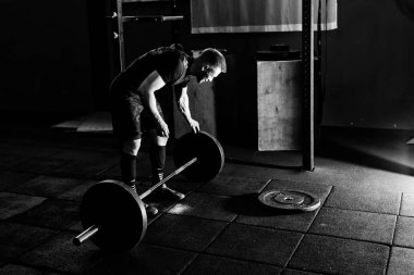 Sakallı adam ağırlık koyarak spor salonunda açık bar. Egzersiz halter ile hazırlanıyor. Vücut geliştirmeci üzerinde halter ağırlık koyar. Tam vücut uzunluğu portre