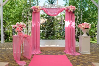 Düğün töreni düğün kemer ile pembe renk için yer çiçek ve pembe bez açık havada ile dekore edilmiştir. Güzel düğün süslemeleri ile özgür yer