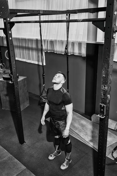 Muscular bearded man preparing to training his biceps and back in gym. Pull-ups. Workout lifestyle concept