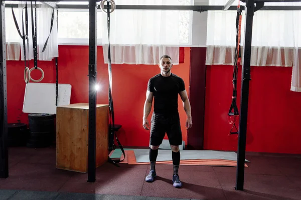 Muscular bearded man preparing to training his biceps and back in gym. Pull-ups. Workout lifestyle concept. Full body length portrait