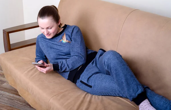 Vackra Unga Leende Kvinna Liggande Soffan Med Hjälp Smartphone Och — Stockfoto