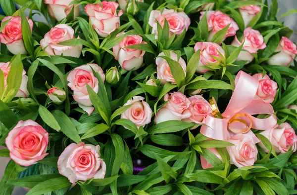 Beautiful pink rose flowers and greenery bouquet background, close up. Roses background, free space. Natural floral background