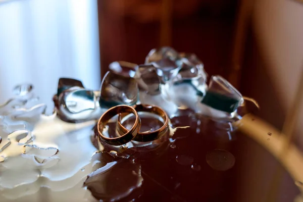 Golden Wedding Rings Ice Cubes Glass Table Copy Space — Stock Photo, Image