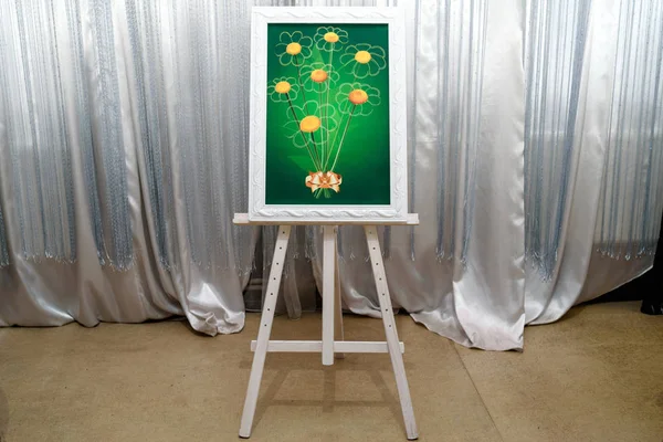 Wedding or birthday wish bouquet of  chamomile for fingerprints of guests on green background in white frame. Wedding decorations indoors, free space