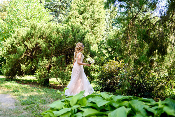 Beautiful bride in wedding dress spinning in the park. Dress develops in the wind. Happy bride in wedding dress turning