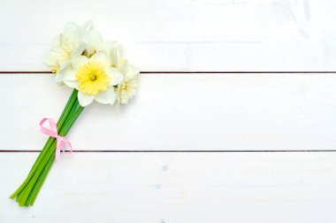 Beyaz ahşap zemin, kopya alanı üzerine Nergis çiçek buket. Üstten görünüm, düz yatıyordu. Beyaz nergis. Bahar çiçekleri. Tebrik kartı için 8 Mart (kadınlar günü), anneler günü. Paskalya arka plan bahar