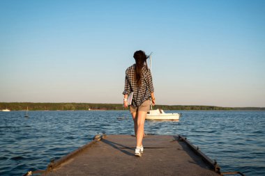 Arkadan görünüşü sketchbook ve el yaz boş alan iskelede yürüyüş kalem olan casual esmer kadın. Tatil, seyahat ve Özgürlük kavramı