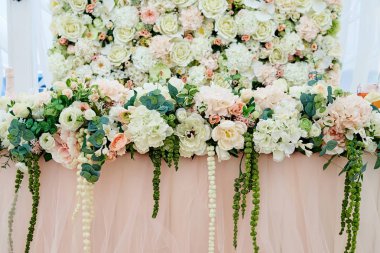 Düğün masada yemyeşil çiçek aranjman. Düğün presidyum restoranında, boş alan. Çiçekler, yeşil, pembe kumaş ve ampuller ile yeni evliler için ziyafet tablo düğün. Lüks düğün süslemeleri