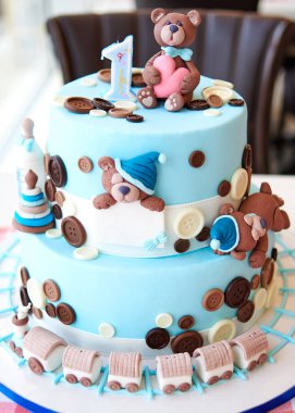 Çok katmanlı mavi Doğum günü pastası düğmesini, oyuncaklar, ayılar, lokomotif ve üst bir numara ile dekore edilmiş, kopyalama için metin alanı 