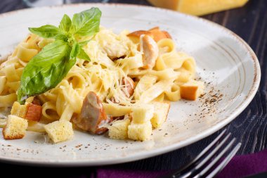 Mantar, parmesan peyniri, fesleğen ve kremsi beyaz tabak içinde baharat biber soslu lezzetli kremsi İtalyan makarna yakın çekim