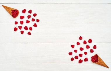 Olgun tatlı ahududu dondurma waffle koni, kopya alanı. Beyaz ahşap zemin, boş alan üzerine taze çilek. Yaz ve sağlıklı gıda kavramı. Üstten görünüm, düz yatıyordu. Çilek arka plan