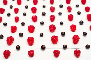 Olgun tatlı ahududu ve siyah frenk üzümü, boş satırlar. Taze çilek Beyaz ahşap zemin üzerinde. Yaz, sağlıklı gıda kavramı. Çilek arka plan