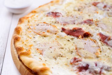 Taze peynirli pizza jambon ve beyaz tabakta krema sos ile kapatın. Geleneksel İtalyan mutfağı, kopya alanı. Gıda, sığ derinlik-in tarla
