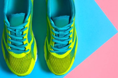 Çift spor ayakkabı renkli arka plan üzerinde. Pembe ve mavi pastel arka plan, kopya alanı üzerinde yeni spor ayakkabıları. Genel gider atış koşu ayakkabıları. Üstten görünüm, düz yatıyordu