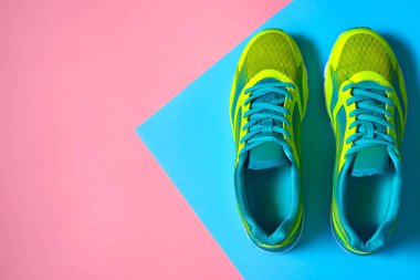 Çift spor ayakkabı renkli arka plan üzerinde. Pembe ve mavi pastel arka plan, kopya alanı üzerinde yeni spor ayakkabıları. Genel gider atış koşu ayakkabıları. Üstten görünüm, düz yatıyordu