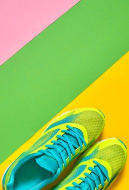 Çift spor ayakkabı renkli arka plan üzerinde. Yeşil, sarı ve pembe arka plan, kopya alanı üzerinde yeni spor ayakkabıları. Genel gider atış koşu ayakkabıları. Üstten görünüm, düz yatıyordu