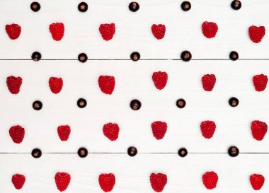 Olgun tatlı ahududu ve siyah frenk üzümü, boş satırlar. Taze çilek Beyaz ahşap zemin üzerinde. Yaz, sağlıklı gıda kavramı. Çilek arka plan