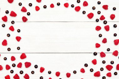 Daire kareden olgun tatlı ahududu ve siyah kuş üzümü, boş alan. Taze çilek Beyaz ahşap zemin üzerinde. Yaz, sağlıklı gıda kavramı. Çilek arka plan