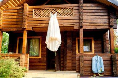 Güzel beyaz gelinlik ve damat kopya alanı kahverengi ahşap ev açık havada, balkonda asılı uygun. Gelin sabah, düğün kavramı