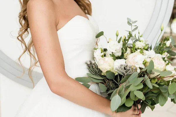 美丽的新娘在白色礼服举行郁郁葱葱的婚礼花束玫瑰和桉树绿地室内 复制空间 婚纱婚礼细节新娘手中的新娘花束 — 图库照片