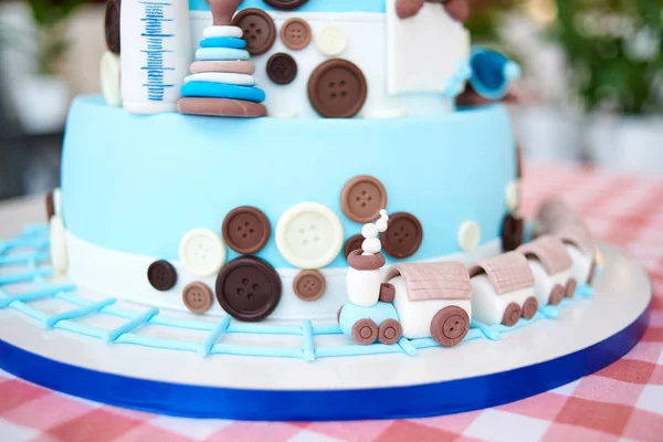 クローズ アップのボタンや市松模様のテーブル クロス コピーのテキストのための領域のおもちゃで飾られたラウンド マルチに機関車階層型ブルー誕生日ケーキ — ストック写真
