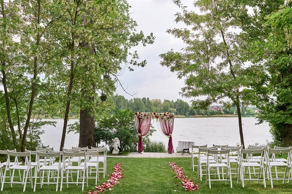 Место Свадебной Церемонии Свадебной Аркой Украшенной Тканью Цветами Белыми Стульями — стоковое фото