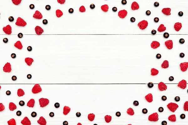 Daire kareden olgun tatlı ahududu ve siyah kuş üzümü, boş alan. Taze çilek Beyaz ahşap zemin üzerinde. Yaz, sağlıklı gıda kavramı. Çilek arka plan