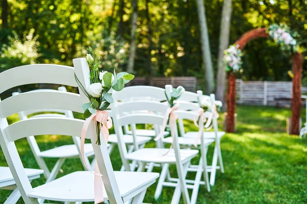 Weiße Frische Blumen Mit Rosa Schleife Auf Dem Hochzeitsstuhl Auf — Stockfoto