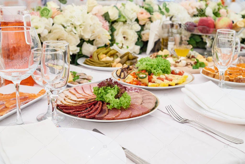 Cold meat plate on celebratory dinner table, copy space. Meat platter with selection on wedding banquet