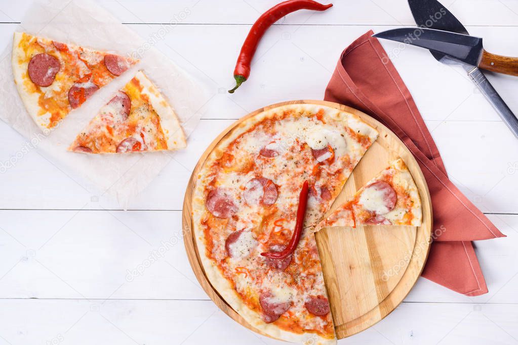 Hot sliced classic pepperoni pizza on wooden board, copy space. Fresh pizza with pepperoni, mozzarella and tomato sauce, copy space. Italian traditional cuisine, food. Top view, flat lay