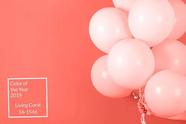 Kadın holding grup mercan arka plan, kopya alanı üzerinde pembe balonlar. Yıl 2019 rengi. Noel, Doğum günü, Sevgililer günü, düğün, tatil kavramı