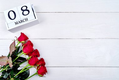 Beyaz ahşap arka plan, metin için kopya alanı küp takvim ile güzel kırmızı gül. Tarihi beyaz blok takvim Dünya Kadınlar günü, 8 Mart için kaydedin. Tebrik kartı. Üstten görünüm, düz yatıyordu