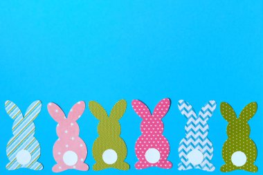Paskalya tavşanı dekorasyon mavi arka plan, kopya alanı üzerinde. DIY tatil elişi renkli tavşan. Düz yatıyordu, en iyi görünüm. Kağıt tavşan kesik sınır. Paskalya tebrik kartı. Mutlu Paskalya kavramı. 