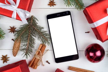 Noel dekorasyonları ahşap zemin, kopya alanı üzerine sunuyla app için boş beyaz ekran ile mobil akıllı telefon yakın çekim. Düz yatıyordu, en iyi görünüm. Noel uygulama şablonu sahte 