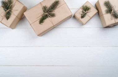 Noel hediye kutuları ile arka plan beyaz ahşap arka planda, boş alan köknar ağacı dalları ile kraft kağıt sarılı. Kopya alanı düz yatıyordu, en iyi manzaralı 