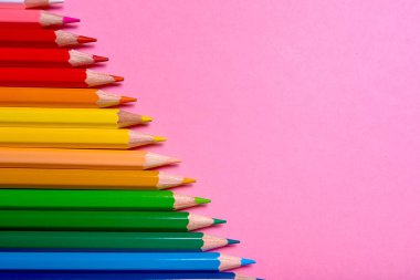 Kalemler üzerinde pastel pembe renk, yakın çekim. Renkli kalemler ayarla, alanı Kopyala. Boya kalemi. Üstten görünüm, düz yatıyordu. Okul hazırlıkları kavramı kolej. Arka plan