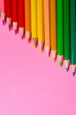 Kalemler üzerinde pastel pembe renk, yakın çekim. Renkli kalemler ayarla, alanı Kopyala. Boya kalemi. Üstten görünüm, düz yatıyordu. Okul hazırlıkları kavramı kolej. Arka plan