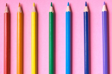 Kalemler üzerinde pastel pembe renk, yakın çekim. Renkli kalemler ayarla, alanı Kopyala. Boya kalemi. Üstten görünüm, düz yatıyordu. Gökkuşağı. Okul hazırlıkları kavramı kolej. Arka plan