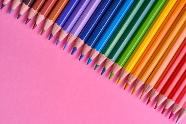 Kalemler üzerinde pastel pembe renk, yakın çekim. Renkli kalemler ayarla, alanı Kopyala. Boya kalemi. Üstten görünüm, düz yatıyordu. Okul hazırlıkları kavramı kolej. Arka plan