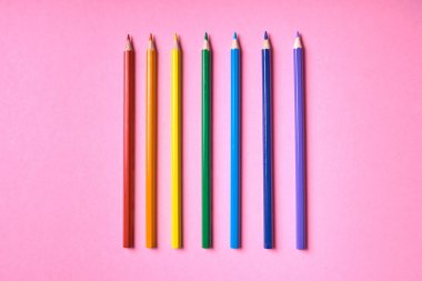 Kalemler üzerinde pastel pembe renk, yakın çekim. Renkli kalemler ayarla, alanı Kopyala. Boya kalemi. Üstten görünüm, düz yatıyordu. Gökkuşağı. Okul hazırlıkları kavramı kolej. Arka plan