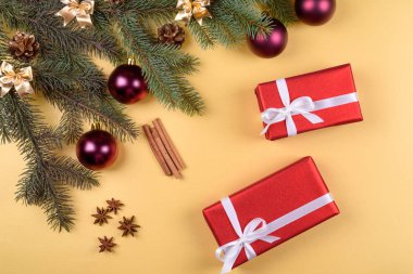Noel arka plan kırmızı hediye kutuları, köknar ağacı dalları ile cam topları, çam kozalakları, tarçın ve Yıldız anason altın arka plan üzerinde boş alan. Kırmızı lüks yeni yıl hediye, kopya alanı