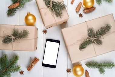 Noel arka plan boş beyaz ekran, hediyeler, çam dalları, koniler, ahşap zemin, kopya alanı üzerine tarçın ile cep telefonu ile. Düz yatıyordu, en iyi görünüm. Noel uygulama şablonu sahte 