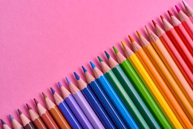 Kalemler üzerinde pastel pembe renk, yakın çekim. Renkli kalemler ayarla, alanı Kopyala. Boya kalemi. Üstten görünüm, düz yatıyordu. Okul hazırlıkları kavramı kolej. Arka plan