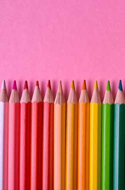 Kalemler üzerinde pastel pembe renk, yakın çekim. Renkli kalemler ayarla, alanı Kopyala. Boya kalemi. Üstten görünüm, düz yatıyordu. Okul hazırlıkları kavramı kolej. Arka plan