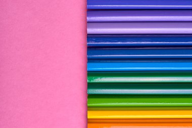 Kalemler üzerinde pastel pembe renk, yakın çekim. Renkli kalemler ayarla, alanı Kopyala. Boya kalemi. Üstten görünüm, düz yatıyordu. Okul hazırlıkları kavramı kolej. Arka plan