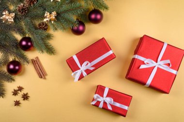 Noel arka plan kırmızı hediye kutuları, köknar ağacı dalları ile cam topları, çam kozalakları, tarçın ve Yıldız anason altın arka plan üzerinde boş alan. Kopya alanı düz yatıyordu, en iyi manzaralı 